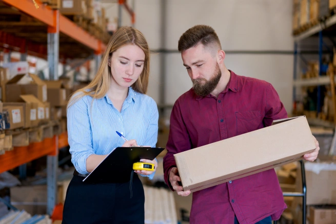 Warehouse staff reviewing packages while handling common challenges in freight forwarding operations
