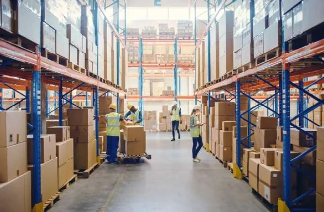 Warehouse employees processing inventory in storage aisles with warehouse workflow automation.